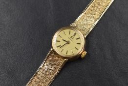 A ladies 1970's 9ct gold Omega wrist watch having a gold baton numeral dial to small gold face