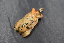 A carved bumble bee jasper pendant in the form of a flying insect having a yellow metal loop,