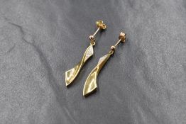 A pair of 9ct gold diamond set drop earrings, the pave set diamond chips within a twisted ribbon