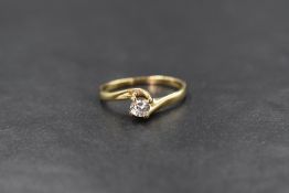 A 9ct gold cubic zirconia set solitaire ring, the round brilliant cut cubic zirconia in a cross over