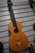 An antique Parlour guitar having later tailpiece and steel strings, no visible label, in card case