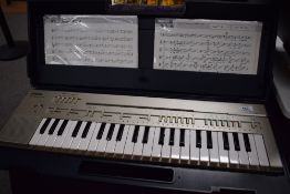A Yamaha Portasound PC-100 electronic keyboard, in original carry case, includes several playcards