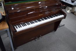 A modern or vintage upright piano in mahogany case, branded Bell, manageable size, six and a half