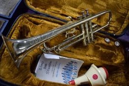 A vintage brass Corton trumpet, sold with fitted case, music and accesories