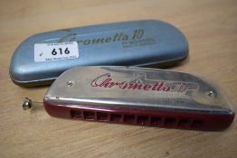 A vintage cased Hohner Chrometta 10 harmonica