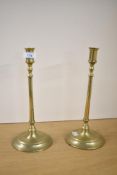 A pair of late 19th to 20th-century brass chamber sticks, of elongated form with rounded bases,