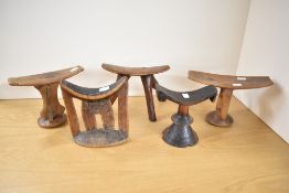 A quantity of five African Tribal carved wood head rests, compromising various shapes, some with