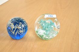 Two 20th-century studio art glass paperweights, to include a green and white firework example and
