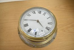 A late 19th to 20th-century brass-cased bulkhead ships clock, featuring a white dial with Roman