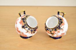 A pair of Royal Crown Derby 'Imari' pattern condiment pots of circular form raised on a footed base,