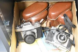 Two 35mm cameras, an Agfa Optima I and an Exakta Exa Iia, both with leather cases and straps and