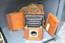 A wooden plate camera, with three plate holders.