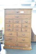 A 20th-century wooden apothecary tabletop cabinet, featuring sixteen small drawers, each fitted with