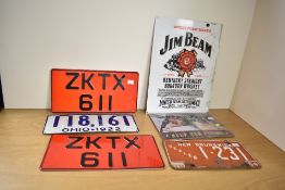 A mixed lot of vintage license plates, including an American Ohio 1922 plate and a New Brunswick,