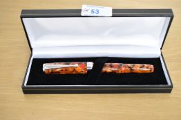 A boxed Sigma converter fill fountain pen in Red, Black and Yellow Marble having Iridium Point