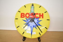 A late 20th-century German Bosch plastic advertising wall clock in a spark plug design with the