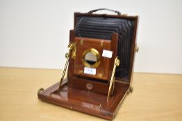 A wooden bellows camera with brass fixings. Engraved on the lens mount 'T T & H', probably referring