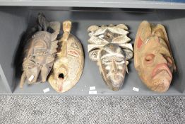 Set of four African hand-carved wooden tribal masks, presumed Ivory Coast examples, featuring