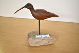 A small contemporary hand-carved wooden shorebird sculpture, likely a Curlew or Whimbrel, mounted