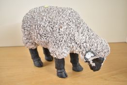 A contemporary resin grazing sheep ornament, with a textured coat, unmarked, 30cm length.