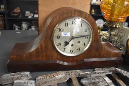 A 1920's mahogany 'Napoleon hat' arched mantel clock, the dial with Arabic hours and three winding
