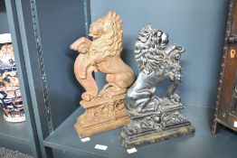 Two late 19th to early 20th-century cast iron Rampant Lion door porters, of differing forms,