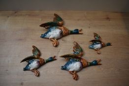 A group of four graduated Beswick Pottery flying mallard duck wall plaques comprising model