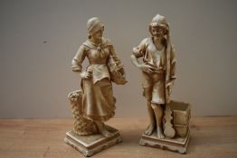 A pair of porcelain figures, one depicting a male water bearer, the other a female carrying a basket