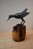 A 20th century patinated metal bird study perched on metal log effect base, measuring 25.5cm tall.