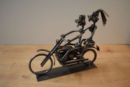 A decorative metal figure group constructed from welded nuts, bolts and other fittings, depicting