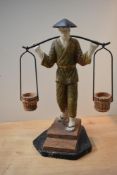 A large Oriental design resin figure depicting a water carrier, measures 43cm tall.