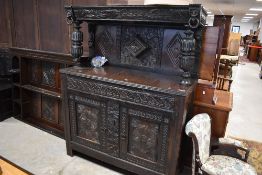 A traditional oak composite court cupboard having typical carved decoration including lion masks