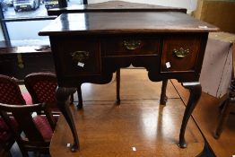A Georgian oak lowboy of typical design , with brass drop handles to drawers over shaped apron and