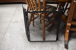 A modern black painted wrought iron type three section spark guard 61cm high