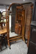 A large Edwardian inlaid mahogany cheval mirror, the arched and bevelled mirror plate within