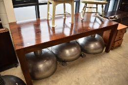 A modern hardwood dining table on chunky square legs, approx. 200 x 100cm