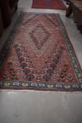 A traditional Persian style rug, quite worn and faded, approx. 200 x 92cm