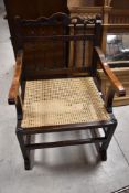 A 20th century cane seated chair, with spindled back and shaped arms , seat height 41cm