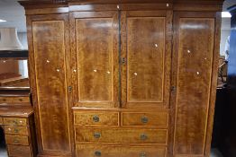 An Edwardian quadruple breakfront wardrobe having central press and drawer section, on bracket feet,