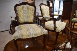 A pair of modern reproduction French design armchairs, with carved foliate decoration and