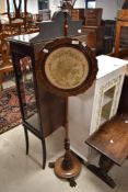 A Victorian rosewood pole screen, with circular fret-cut frame enclosing a machined tapestry (af)