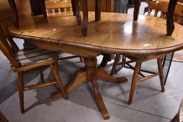 A modern pine rounded rectangular pedestal dining table with demi-lune leaves, 72cm x 151cm x 91cm