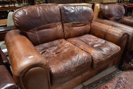 A modern brown leather two seater settee and armchair
