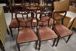 A set of six Victorian rosewood/mahogany balloon and rail back dining chairs having drop in seats