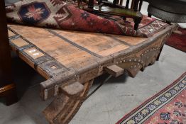 An antique Indian hardwood and wrought iron mounted bullock cart, converted to coffee table, with
