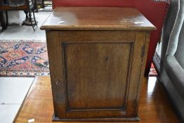 A 19th Century oak cabinet of small proportions having two drop flap sections internally ,