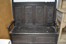 A traditional oak box settle having carved panel back, width approx. 131cm