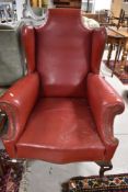 An early to mid 20th Century red leather wing back armchair