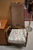 A vintage stained frame armchair having canework back