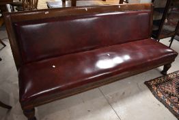 A late 19th/early 20th century oxblood leather covered/upholstered bench, of simplistic design